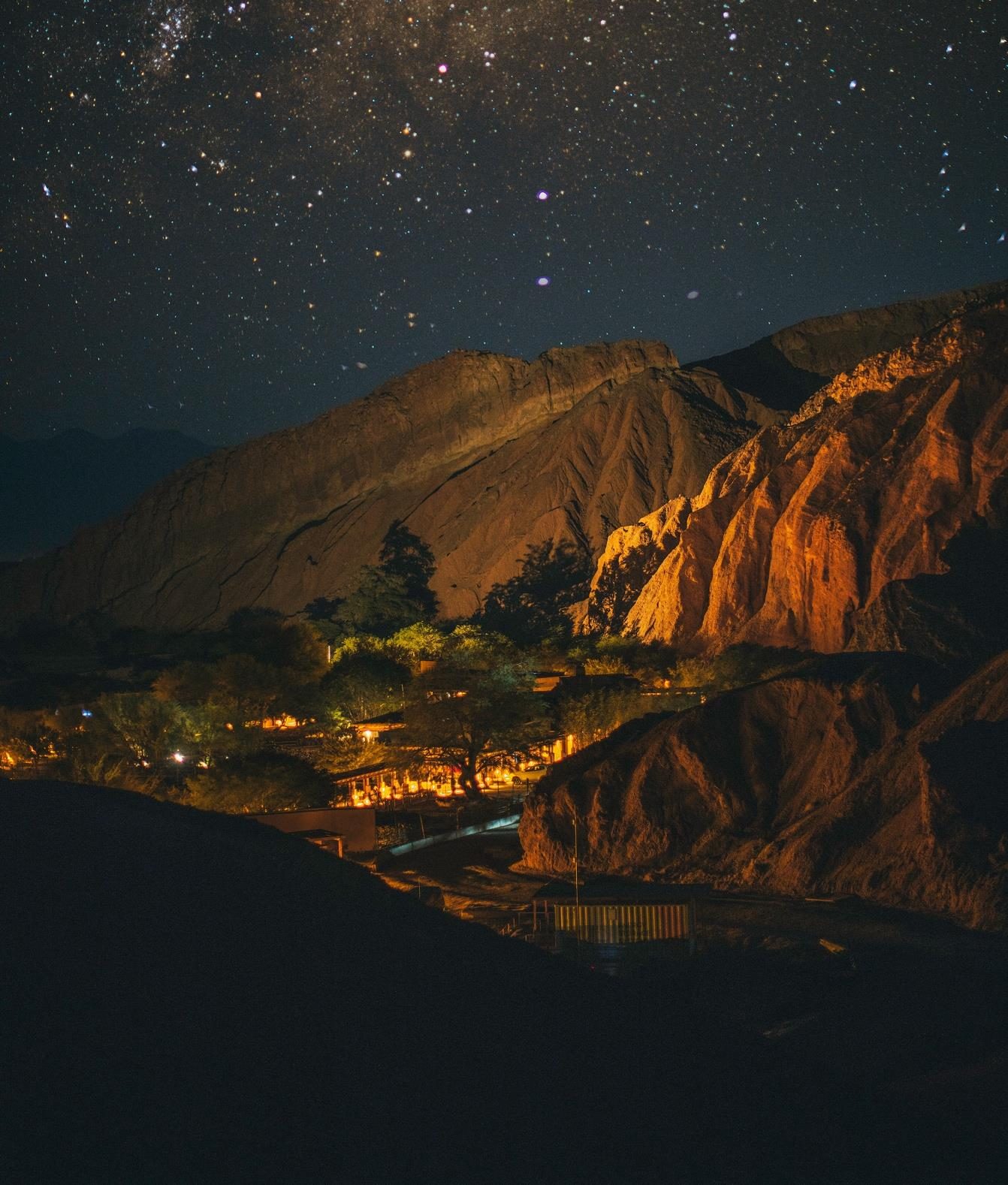 A starry sky above the lights of a village in the Atacama Desert