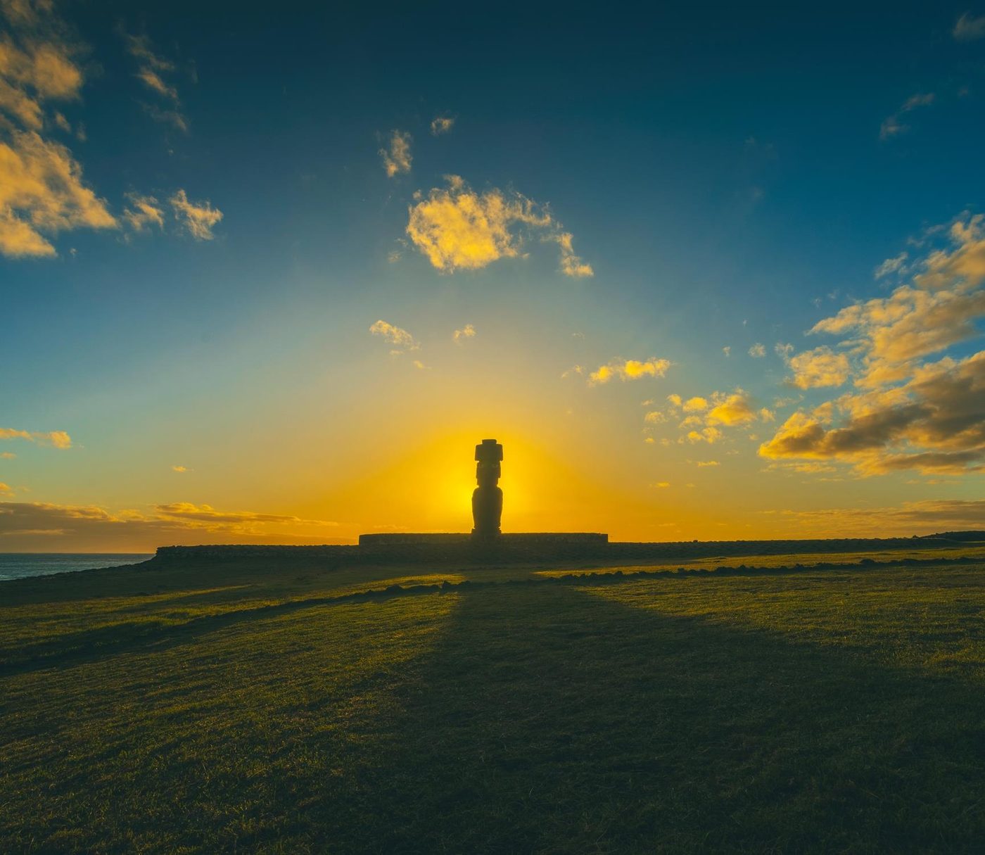 The silhouette of a moai against the rising sun over the Pacific