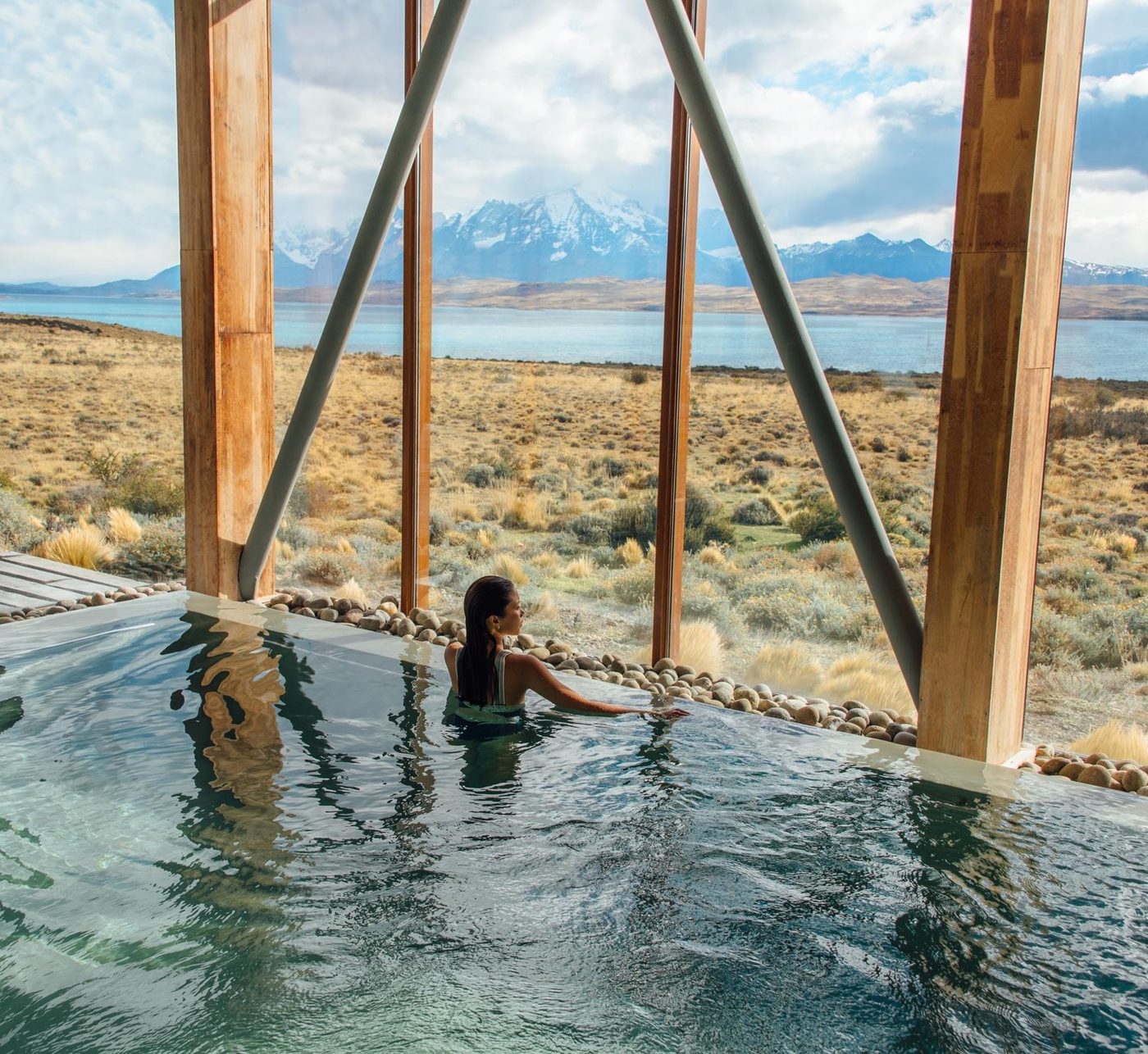 The lodge pool with windows opening towards the lake and the Patagonian range