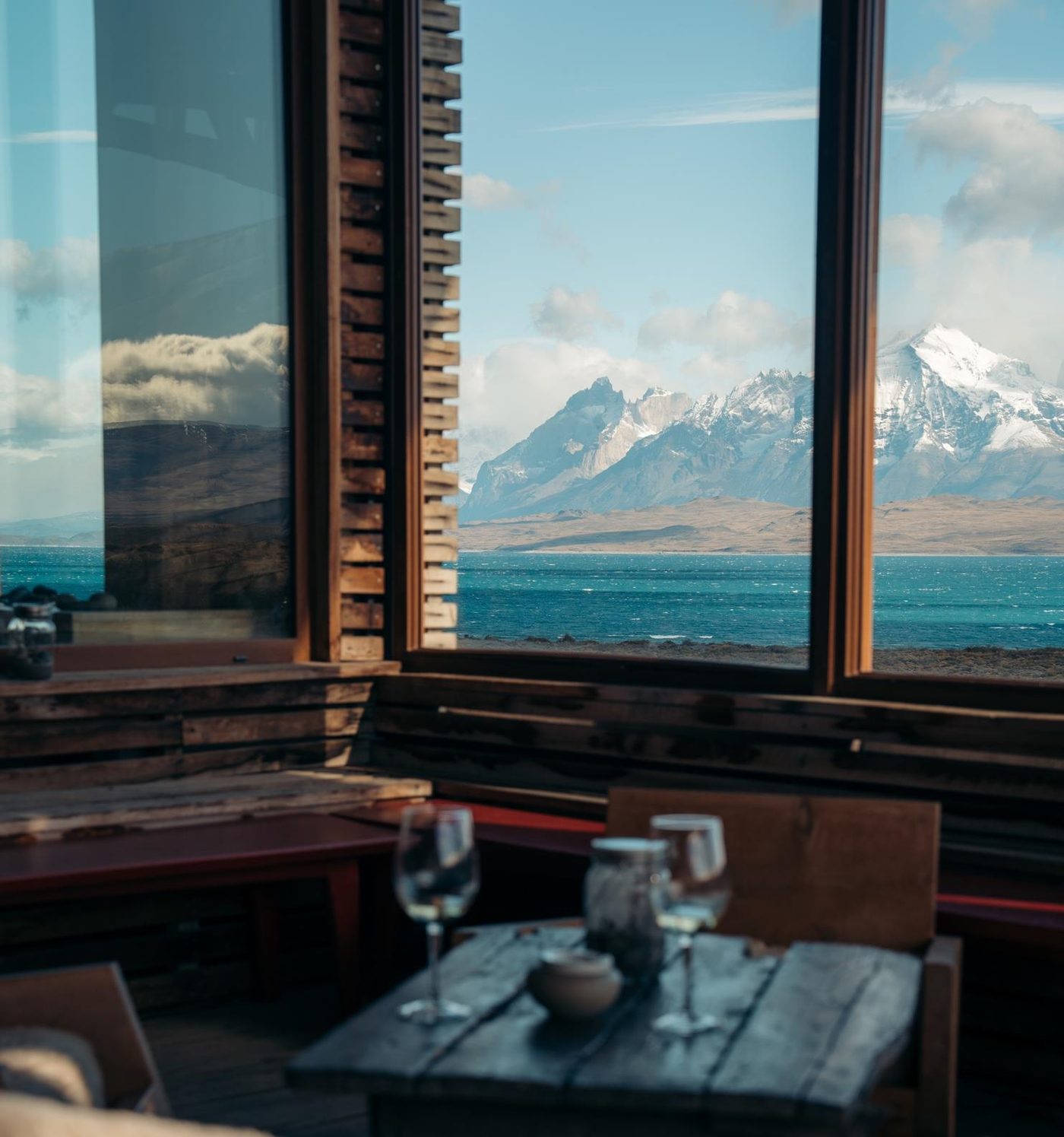 A lodge window looking out to the lake and the mountains of Torres del Paine